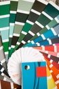 Selection of the paint color for decorative home repairs to the palette with layouts. A fan of shades in your hand inside the home