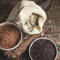 Selection of red, black and mixed rice on an old wooden background Royalty Free Stock Photo