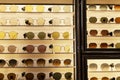 A selection of sunglasses of different shapes, colors and sizes on a shop window. Front view