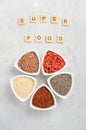 Selection of superfoods in white bowls on gray concrete background. Quinoa, chia, goji berry and flax seeds. Royalty Free Stock Photo