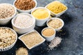 Selection of whole grains in white bowls - rice, oats, buckwheat, bulgur, porridge, barley, quinoa, amaranth