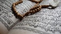 Selectiv focus of tasbih on the old Koran & x28;the Quran uses the arob language& x29; in a dim and solemn light