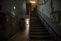 Selective blur on an old and neglected stairwell in a public hallway, dark and poorly lit, waiting for urban renewal in the city Royalty Free Stock Photo