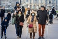 Selective blur on Old senior man & woman, couple, with facemask, wlaking in a street in Bordeaux surronded by families on covid