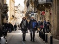 Selective blur on Old senior man & woman, couple, with facemask, wlking in a street in Bordeaux with shopping groceries bags