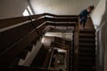 Selective blur on old staircase swirling spiral stairway with unidentified woman running in an abandoned bankrupted dwelling Royalty Free Stock Photo