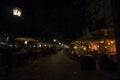 Selective blur on packed patios of a cafe restaurant with people sitting, in evening nightlife, not respecting social distancing Royalty Free Stock Photo