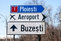 Selective blur on a romanian roadsign in the streets of bucharest indicating the directions to Ploiesti and Buzesti and the way to