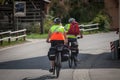 Selective blur on a senior couple riding bicycle doing bike touring in Stara Fuzina, in the alps, with luggage on the bicycle Royalty Free Stock Photo