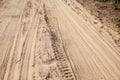 Selective blur on a tire track on a sand, traces of tyres and wheels of cars and vehicles driving off road on a dirt path, a sandy Royalty Free Stock Photo