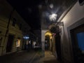 Selective blur on the Trubarjeva cesta street at night with aflare on a lamp, people passing by and nearby shops. Royalty Free Stock Photo