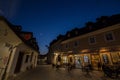 Selective blur on the Trubarjeva cesta street at night with people passing by and a nearby bar cafe.