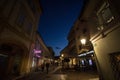 Selective blur on the Trubarjeva cesta street at night with people passing by and a nearby bar cafe and shops. Royalty Free Stock Photo