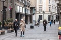 Selective blur on two women, friends, smiling, walking holding cups of coffee to go, to drink a hot beverage outdoors as takeaway. Royalty Free Stock Photo