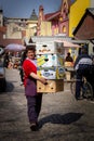 Selective blur on a woman, a worker, carrying heavy boxes of fruits on Somborska Pijaca Green market.