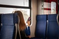 Selective blur on young girl, Generation Z, sitting in an SBahn train in Cologne with her smartphone mobile phone