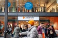 Selective blur on a Zalando logo on their outlet store of Cologne with blurred clients passing by. Royalty Free Stock Photo