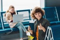 Selective focus on boy holding passport and showing thumb up while sitting on blue seat Royalty Free Stock Photo