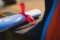 Selective and close-up focus of a university graduate holds a degree certificate and graduation cap celebrates in the graduation c Royalty Free Stock Photo