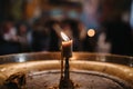 Selective closeup of a burning candle in a church
