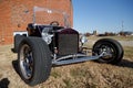 Selective closeup focus of a vintage Ford Model T in front of a red brick building