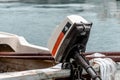 Selective closeup focus of a vintage outboard motor on a boat with the blue sea in the background