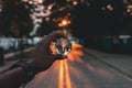 Selective closeup shot of a male holding a glass ball with the reflection of the street lights