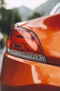 Selective closeup shot of a taillight of an orange car Royalty Free Stock Photo