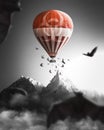 Selective color vertical view of baths flying around a red hot air balloon before the mountains