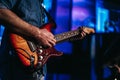 Selective of electric wooden guitar in the hands of a man on a stage Royalty Free Stock Photo