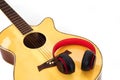 Selective focus, Acoustic guitar and the headphones on white background. Concept of leisure, relaxation and music. Royalty Free Stock Photo