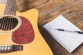 Selective focus of Acoustic guitar , Notebook paper and pen on wood background  and copy space Royalty Free Stock Photo