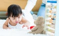 Selective focus adorable caucasian little baby daughter girl, smiling, crawling on the floor, trying collect toy in comfortable Royalty Free Stock Photo