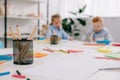 selective focus of adorable kids drawing pictures at table