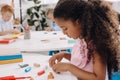 selective focus of african american kid with plasticine sculpturing figure at table