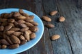 Selective focus on almonds on a white ceramic plate set on a rustic wooden floor Royalty Free Stock Photo