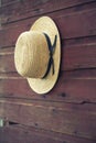 Selective focus of Amish man's straw hat on barn door