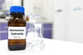 Selective focus of ammonium hydroxide or ammonia solution in glass amber bottle inside a chemistry laboratory with copy space. Royalty Free Stock Photo