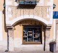 Selective focus on an ancient wall with a window decorated with traditional pretzels. Autumn morning in a small town