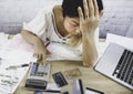 Asian business woman headache and  hand calculating her monthly expenses which she is  stressed trying to find Royalty Free Stock Photo