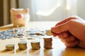 Selective focus Asian men hand put coin into stack with piggy bank on background. Saving plan for retirement planning, pension, Royalty Free Stock Photo