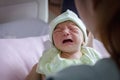 Selective focus of Asian mother looking newborn baby boy crying in hand at hospital Royalty Free Stock Photo