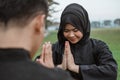 Selective focus of Asian women wearing hijabs wearing pencak silat uniforms with poses of respect for their opponents