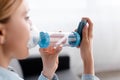 Focus of asthmatic woman using inhaler