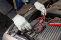 Selective focus an auto mechanic uses a multimeter voltmeter to check the voltage level in a car battery Royalty Free Stock Photo