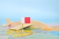 Selective focus of Bahrain flag in blurry world map and wooden airplane model. Bahrain as travel and tourism destination concept.