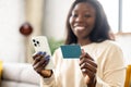 Selective focus at banking card and smartphone in hands of african-american woman Royalty Free Stock Photo