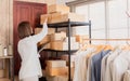 Selective focus Beautiful Asian working woman using tablet check shipping delivery order on shelves. Small business fashion