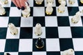 Selective focus of beautiful chess on chessboard. Close up of body part of unrecognizable woman playing in board game on