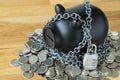 Selective focus on black piggy bank with chains and lock pad and